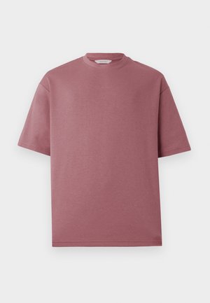 Tricou scurt cu mânecă, de culoare roz, fabricat din bumbac, cu un decolteu rotund și o croială lejeră. Textura pare netedă și moale, fără modele.