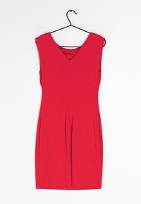 Robe rouge sans manches avec un col en V, présentant une silhouette ajustée, une fermeture éclair au dos et un tissu lisse et extensible.