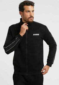 Guess - MIT SEITLICHEM LOGO - Užtrauktuku užsegamas treningas - schwarz Miniatiūros vaizdas 1