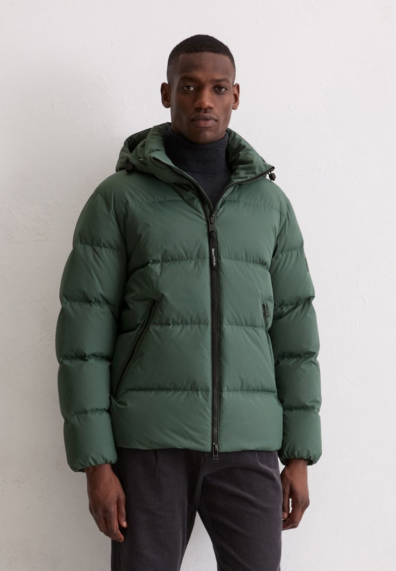 Green puffer jacket with a hood, featuring a front zipper and side pockets. The fabric has a smooth texture with quilted sections.