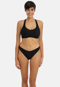 Black bikini featuring a textured fabric, a halter neck design for the top, and low-rise cut for the bottoms. Simple and minimalistic style.