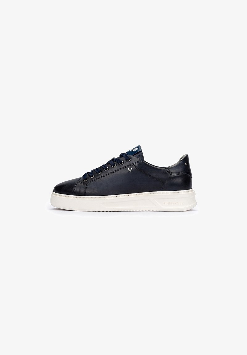 Navy leather sneaker with white rubber sole, round toe, and six eyelets. Features stitched detailing and a logo accent on the side.
