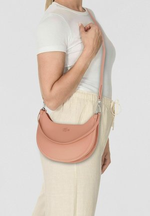 Roze leren schoudertas met een gebogen ontwerp, gestructureerd oppervlak en verstelbare band, gedragen bij een lichtgekleurde outfit.