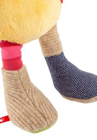 Plush toy feet feature a soft yellow texture, brown corduroy-like material, and a blue patterned fabric with white dots; includes red and green accents.