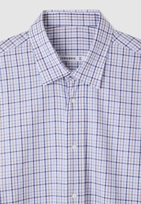 Camicia a quadri in tonalità bianca, blu e marrone. Presenta un colletto a punta, chiusura con bottoni e una trama di tessuto morbida. Taglia XL, di Terranova.