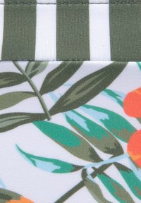 Tissu à motifs présentant des rayures vertes et blanches en haut, avec des feuilles colorées et des accents orange en dessous. Texture lisse, couleurs vives.