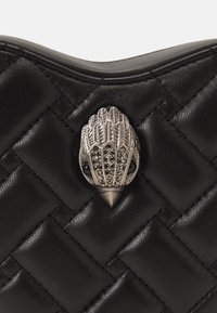Borsa a tracolla in pelle nera con motivo trapuntato, caratterizzata da un clasp a forma di fiore in metallo argentato, che aggiunge texture e dettaglio al design.