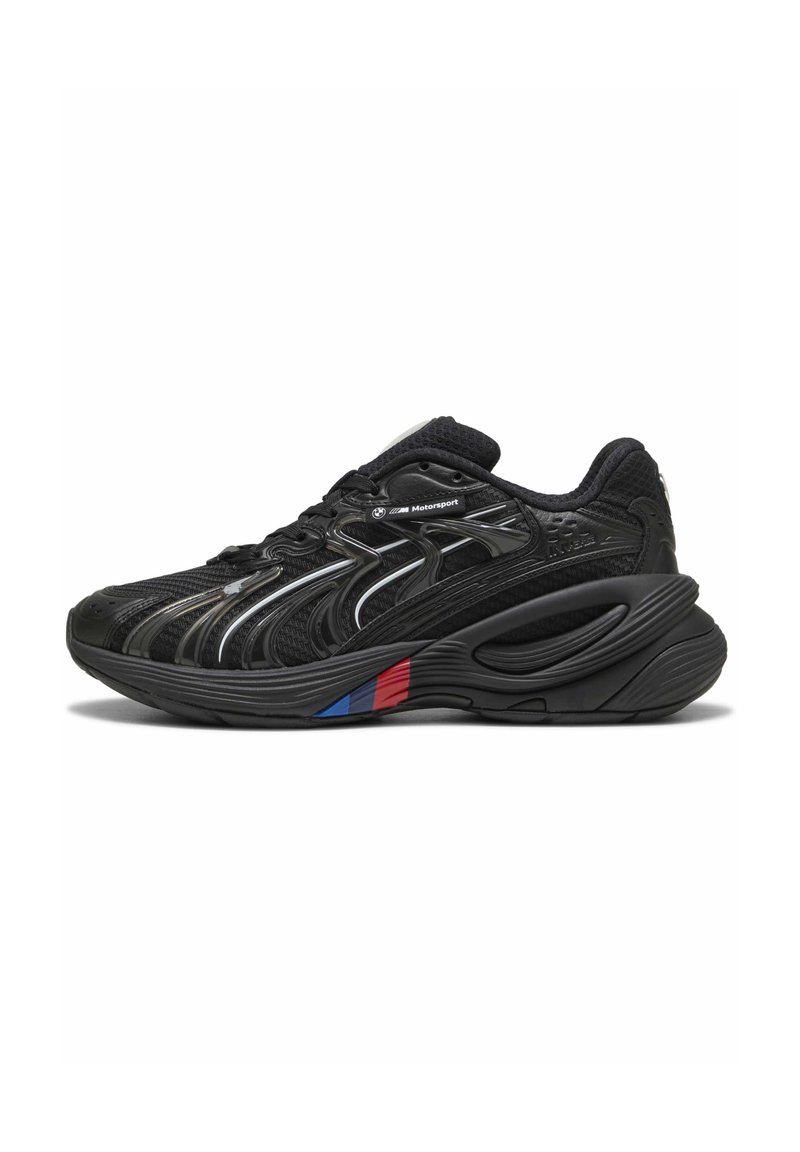 Chaussure de course noire avec tige en mesh et synthétique, semelle incurvée, accents métalliques et une bande tricolore bleue, rouge et blanche sur le côté.