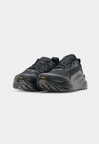 Zwarte sportschoenen met een gestructureerde bovenkant, verstevigde neus en Vibram-buitenzool. Heeft een slank ontwerp met tonale veters en accenten.