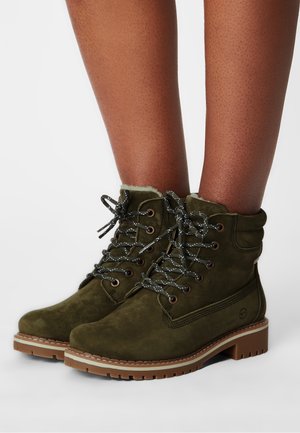 Bottines en daim vert foncé avec des lacets gris, semelle en caoutchouc beige, col rembourré et œillets en métal, avec un design de couture distinctif.
