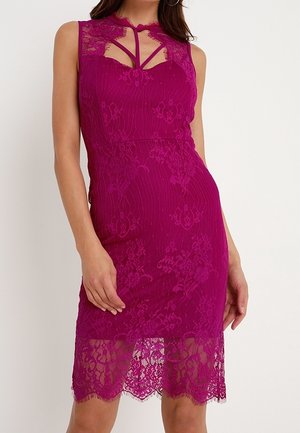 Hihaton polvipituinen magentanvärinen pitsimekko, jossa on kukkakuvio, läpikuultava helma ja avonainen pääntie, jota korostavat ohuet olkaimet.