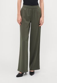 Olive green wide-leg pants made from a smooth, lightweight fabric with an elastic waistband. Paired with black pointed-toe heels.