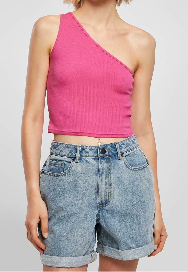 Top corto de una sola manga, de color rosa y con canalé, combinado con pantalones cortos de mezclilla azul claro, de tiro alto, con dobladillos enrollados y bolsillos frontales.