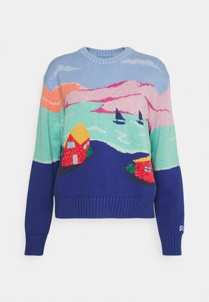 Pull tricoté avec un motif paysager coloré comprenant des collines, deux maisons, des voiliers sur l'eau et un ciel avec des nuages.