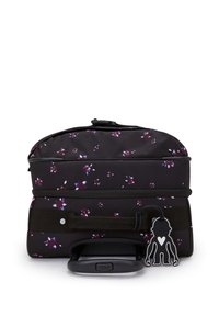 Rullande ryggsäck i svart tyg prydd med små lila och vita blommönster, med ett handtag högst upp och en svart apnyckelring.