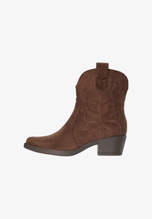 Bota vaquera de ante marrón hasta el tobillo con patrones decorativos cosidos y un tacón bajo apilado sobre un fondo blanco.