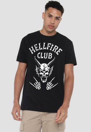 Black cotton t-shirt featuring a large white graphic of a skull with horns, surrounded by the text "HELLFIRE CLUB" and skeletal hands.