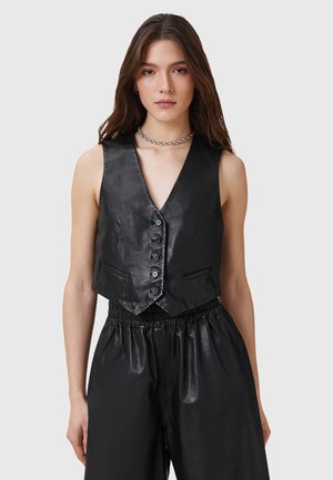 Chaleco negro de cuero sintético con escote en V, cierre de seis botones y dos bolsillos frontales. Textura suave, corte ajustado y diseño corto.