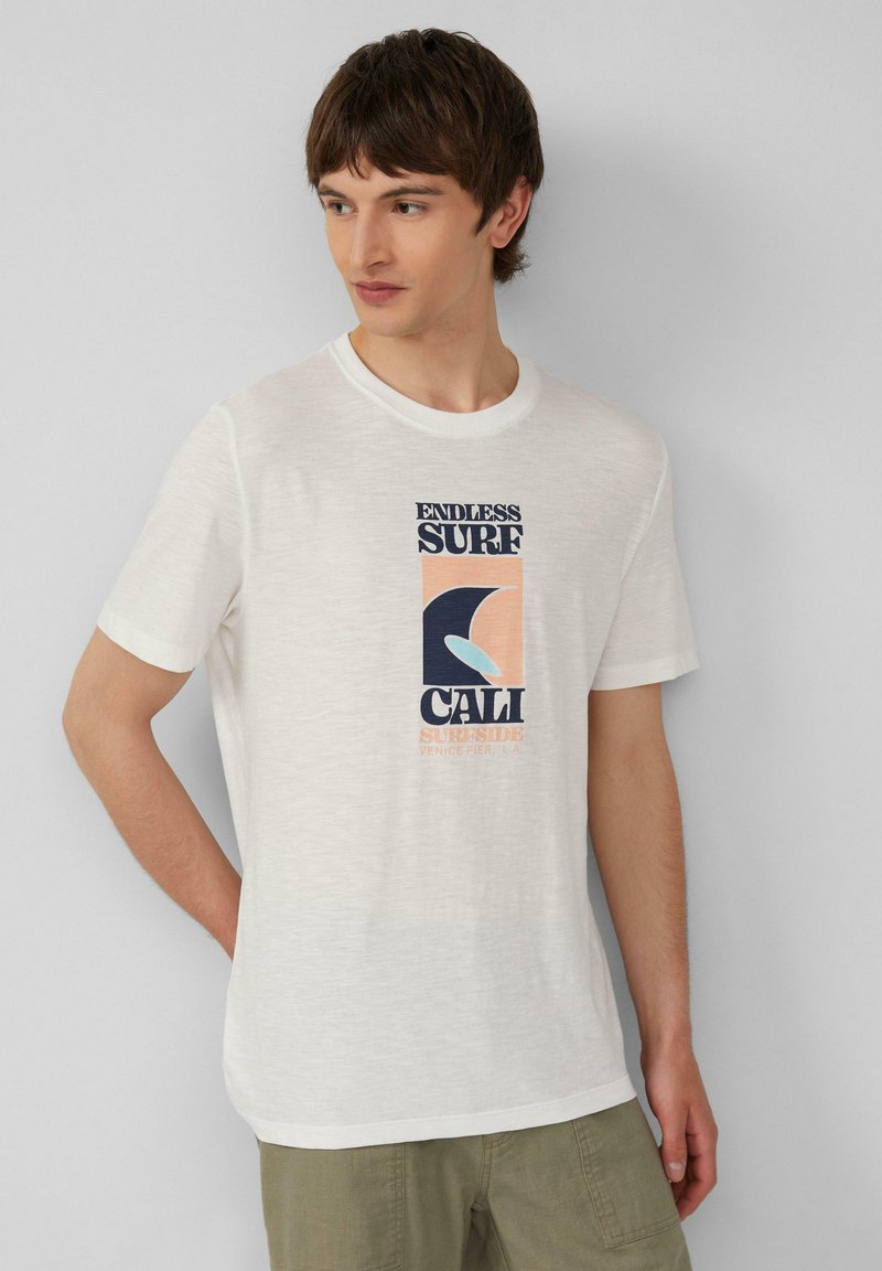 Witte katoenen t-shirt met een grafische print met "ENDLESS SURF", "CALI" en een golvend ontwerp in donkerblauw, koraal en lichtblauw. Korte mouwen, ronde hals.