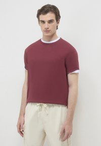 T-shirt corta a maniche con scollo rotondo e polsini bianchi, di colore bordeaux, con una vestibilità comoda e realizzato in cotone morbido.