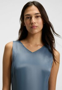 Blaues Satin-Ärmelloses Kleid mit V-Ausschnitt, glatter Textur und minimalistischer Stilistik, mit subtiler glänzender Oberfläche und maßgeschneiderter Passform.