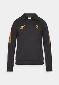 Sort langærmet pullover med krave, der har orange logoer og mønstrede accenter på ærmerne. Fremstillet af et tekstureret stof.