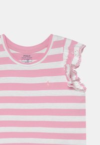 Dívčí růžový a bílý pruhovaný top s volánkovými rukávy a vyšitým logem na hrudi.