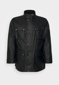 Svart vattentät jacka med hög krage, fyra framfickor med guldfärgade tryckknappar och ett slätt, lätt texturerat tyg.