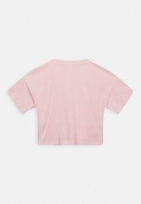 Camiseta cropped rosa em tecido suave, com mangas curtas, decote redondo e textura lisa. Sem padrões visíveis ou detalhes adicionais.