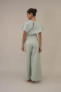 Macaquinho verde menta com mangas largas, detalhe em forma de chave na parte das costas e cintura ajustada. Feito em tecido suave, com um design de perna flare.