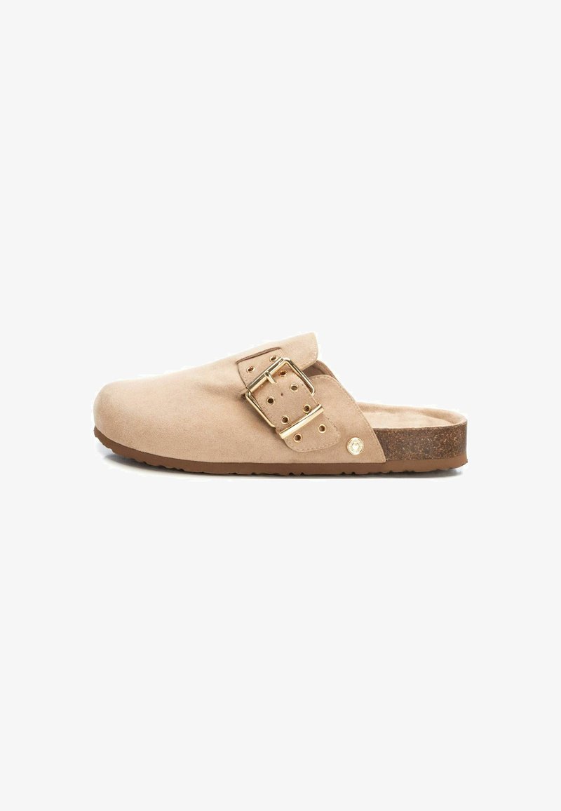Zuecos de ante beige sin cordones con una correa ancha, detalles de hebilla dorada y suela de corcho. Textura suave con un diseño de punta redondeada.