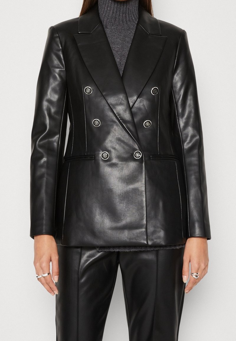 Blazer en cuir noir croisé avec de gros boutons, revers entaillés et deux poches latérales. Texture lisse avec des surpiqûres blanches contrastantes.