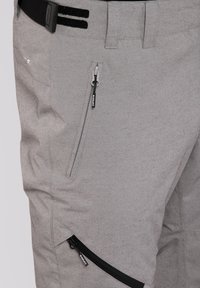 Lichtgrijze broek met een gestructureerde stof, meerdere met rits afgesloten zakken met zwarte accenten en versterkte stiksels voor duurzaamheid.