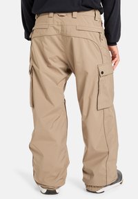 Beige cargo bukser med en afslappet pasform, der har flere sidelommer, elastiske manchetter og et glat, let stof.