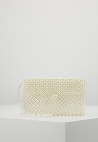Hvid perle clutch taske med en tekstureret overflade. Har en perledetalje og en aftagelig kædetrækrem, der giver mulighed for alsidige bæreoptioner.