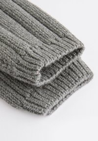 Manches grises en tricot avec une texture côtelée, présentant un fil doux et épais. Les bords sont soigneusement finis, révélant une apparence confortable.