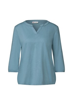 Himmelblaue, locker geschnittene Bluse mit V-Ausschnitt und Dreiviertelärmeln. Hergestellt aus weich fallendem Stoff mit glatter Textur und subtiler Schimmer.