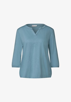 Lichtblauwe, ontspannen blouse met een V-hals en driekwart mouwen. Gemaakt van zachte stof met een gladde textuur en subtiele glans.