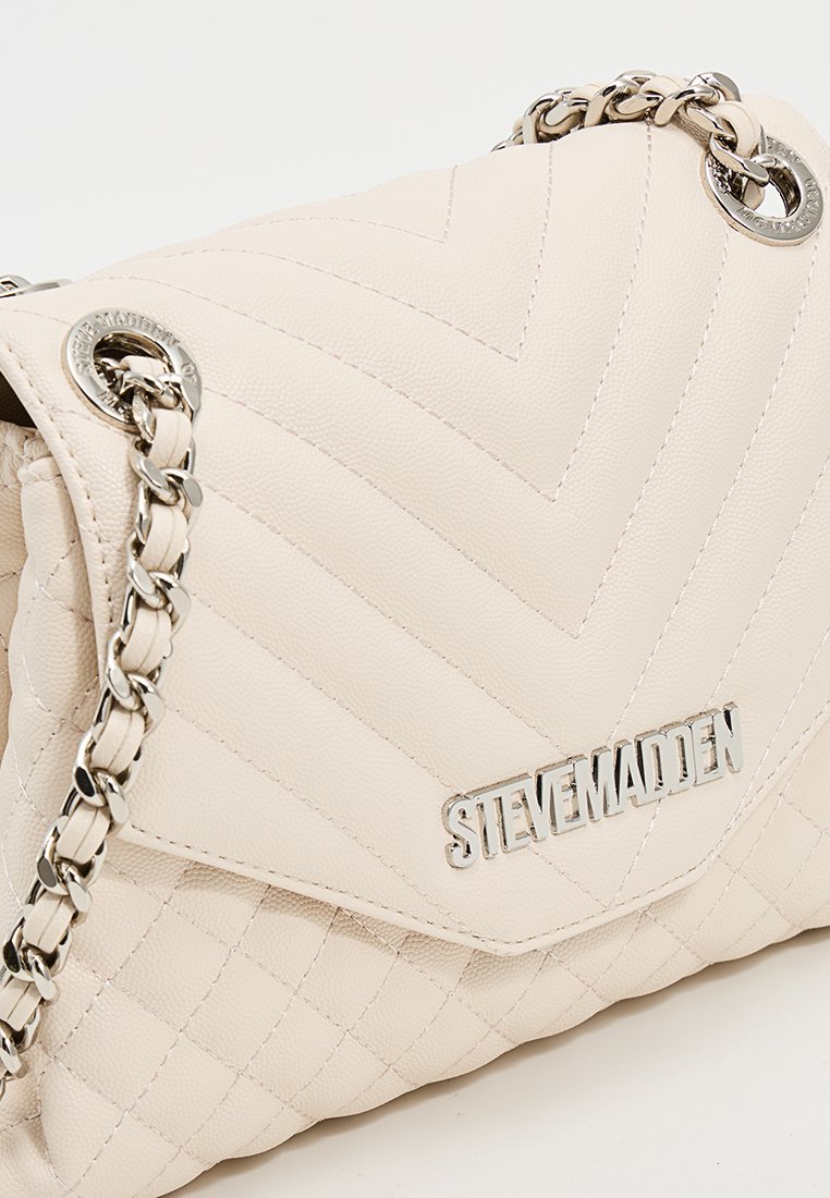 Borsa a mano in pelle quilted crema con tracolla in catena argentata e logo in metallo "Steve Madden" sulla chiusura a pattina.