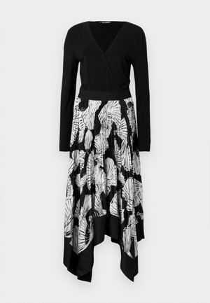 Vestido preto com mangas longas, decote em V e saia plissada com um padrão de folhas brancas. A bainha assimétrica adiciona um toque distintivo.