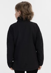 Svart jacka med hög krage, med en slät textur och elastisk nederkant, visad från baksidan utan synlig märkning.