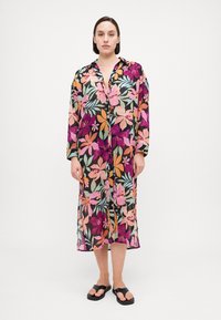 Robe kimono en tissu transparent avec imprimé floral, affichant un mélange de teintes roses, violettes et vertes. Manches longues et fermeture à boutons sur le devant.