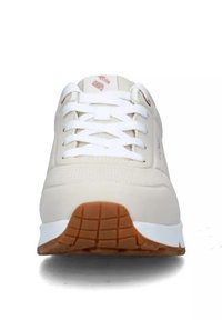 Sneaker beige con lacci bianchi e una parte superiore testurizzata. Presenta una suola in gomma naturale e un branding sottile sulla linguetta e sul lato.