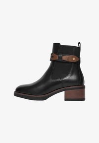 Bota negra de tobillo con tacón apilado marrón, paneles laterales elásticos y tira decorativa de cuero marrón con detalle de botón dorado.