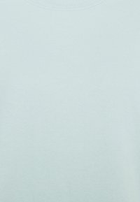 Ljusblå tröja med rund hals, gjord av mjukt tyg, med slät yta utan mönster eller detaljer. Standardpassform och enkel design.