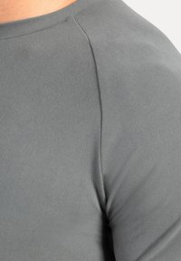 Grijs, aansluitend top met een gladde textuur, met een ronde hals en versterkte schoudernaden. Geen zichtbare patronen of accenten.