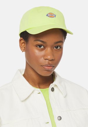 Neon grønn caps med buet skjerm og brodert logo. Hvit denimjakke over en limegrønn skjorte. Glatt tekstur, uformelt design.