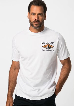 White cotton t-shirt featuring a printed mountain and tree design in orange and black. Short sleeves and crew neckline.