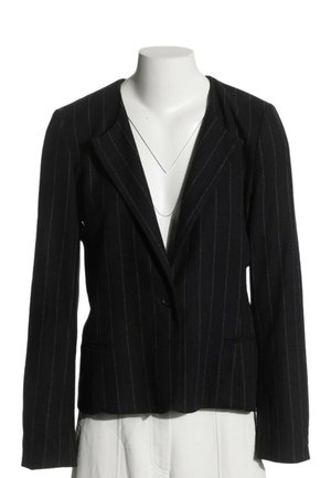 Blazer noir à fines rayures avec fermeture à un bouton, présenté sur un mannequin sans tête portant un pantalon blanc.