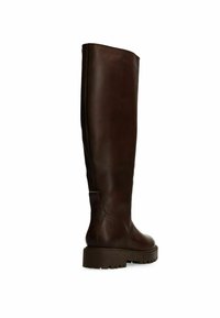 Stivale marrone in pelle fino al ginocchio con superficie liscia, suola spessa e punta leggermente arrotondata; presenta un tacco sottile e una linguetta per il rimovimento.